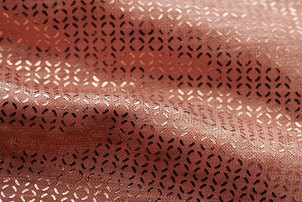 Détail d'un tissu tissé avec une finition textile dorée de KURZ