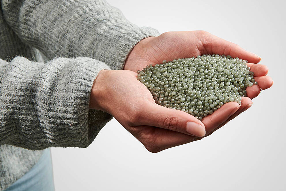 [Translate to Française:] Hands presenting recycled plastic granules from KURZ embossed foils